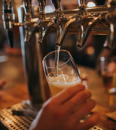 a hand holding a glass of liquid