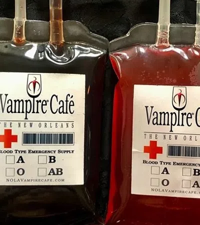 a couple of metal bottles with red labels and a cross on them