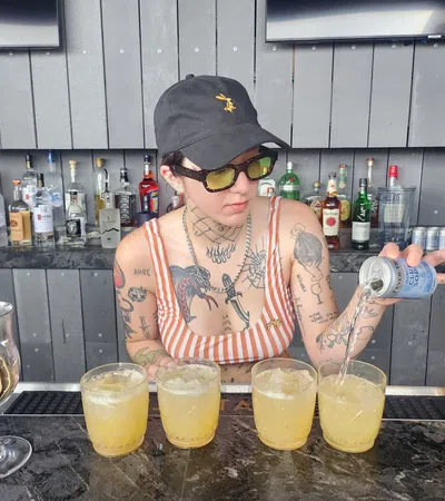 a person pouring a drink into a glass