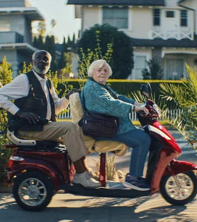 a man and woman riding a scooter