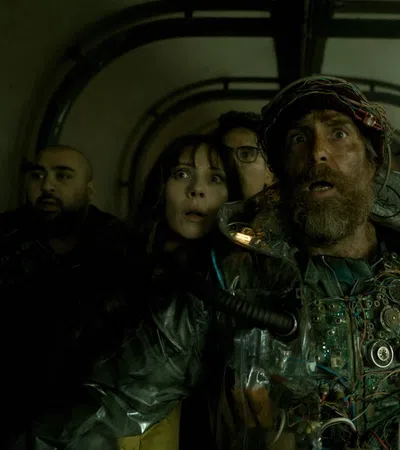 Group of six diverse people appearing frightened inside a dim, enclosed tunnel with shadows.