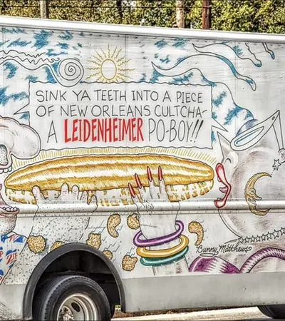 Truck mural featuring a man about to eat a large po-boy sandwich with vibrant New Orleans-themed artwork.