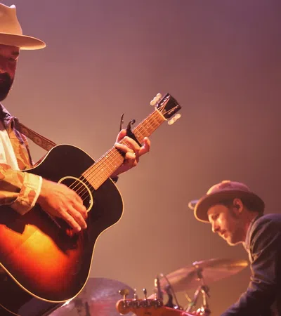 a man playing guitar next to a man playing drums