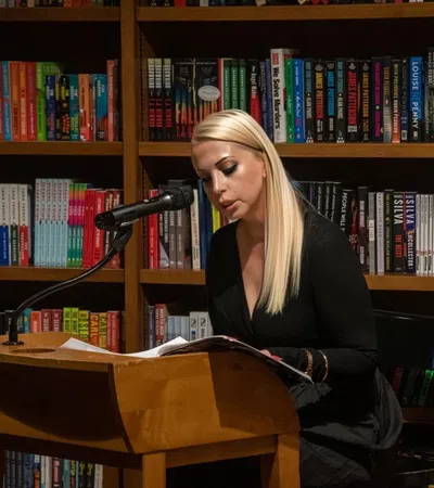a person sitting at a desk in front of a book shelf