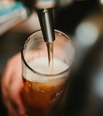 a hand holding a glass of liquid