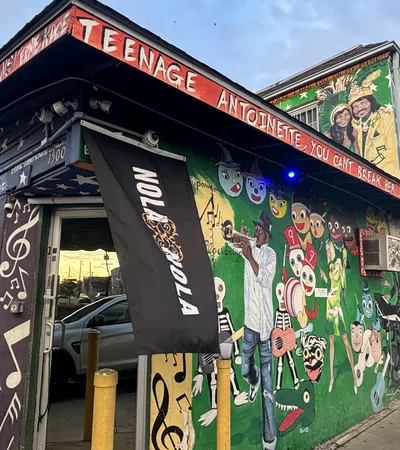 Colorful exterior of Teenage Antoinette adorned with murals and lively art, capturing the essence of community and creativity.