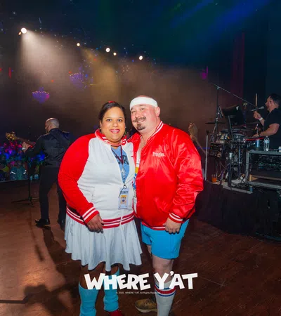 a man and woman posing for a picture in front of a stage