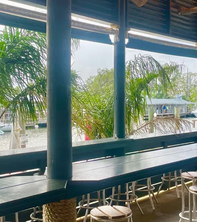 a deck with stools and a body of water in the background
