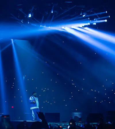 a person on a stage with a crowd watching