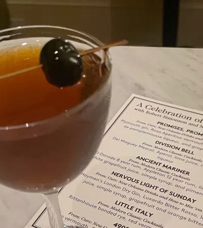 a glass of liquid with a spoon