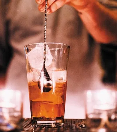 a person pouring liquid into a glass