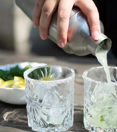 a person pouring a liquid into a glass