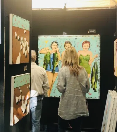 a group of people looking at a wall of art
