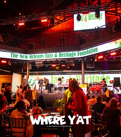 Vibrant stage at the New Orleans Jazz & Heritage Foundation event with musicians performing.