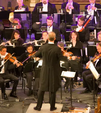 a person standing in front of an orchestra