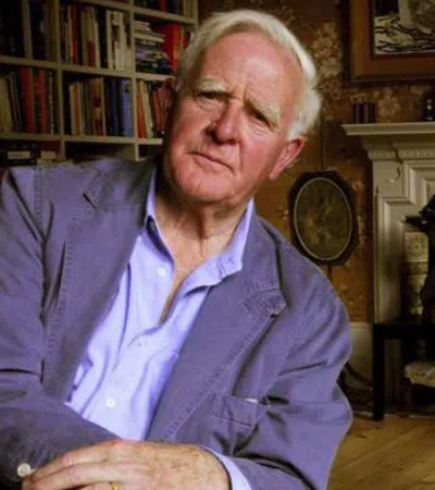 John le Carre sitting in a chair