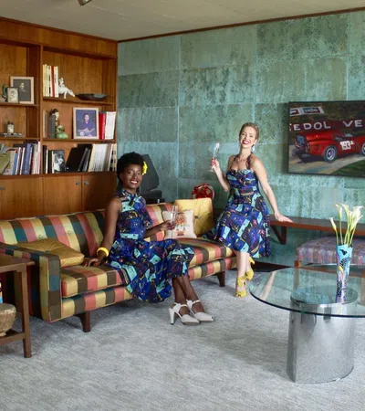 a couple of girls sitting on a couch in a room with a green wall and a table with