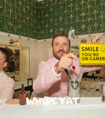a man and a woman sitting at a table with a sign