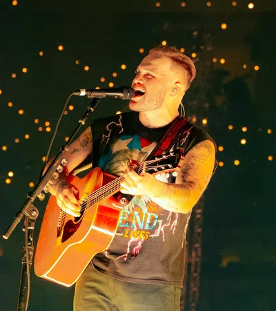 a man playing a guitar on a stage