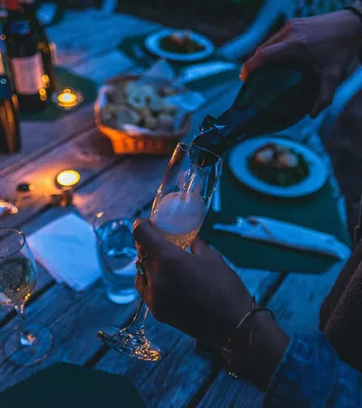 a person pouring wine into glasses