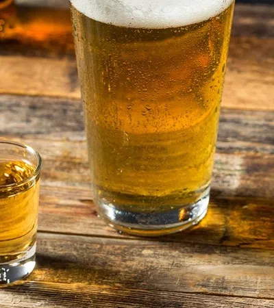 a couple of glasses with liquid in them on a wood table