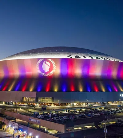 a stadium with a large roof with Mercedes-Benz Superdome in the background