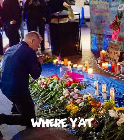 a person kneeling next to a table with flowers and candles