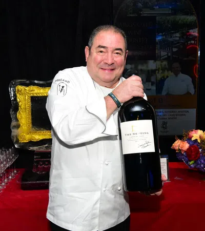 Emeril Lagasse holding a bottle of wine