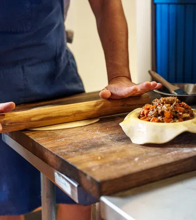 a person cutting a pizza