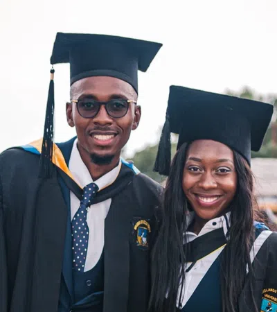 a man and woman wearing graduation gowns and caps
