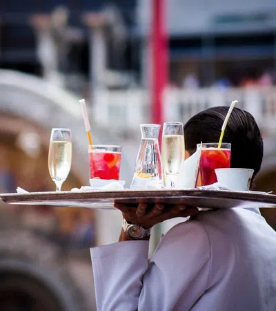 a person holding a tray of drinks