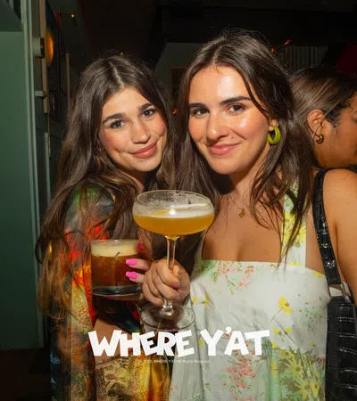 two women holding drinks