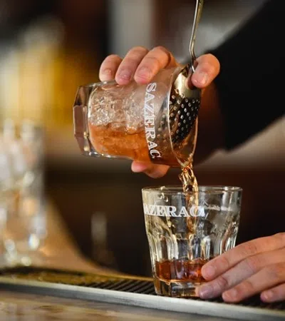 a person pouring a liquid into a glass