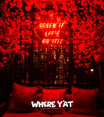 a couch with red pillows and a sign above it