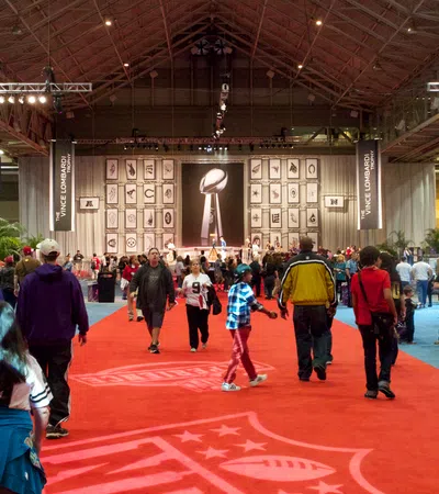 a group of people in a large room with a statue on the wall