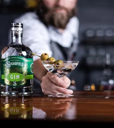a person pouring a drink into a glass bottle