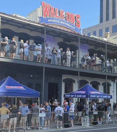 Crowd gathered outside Walk-On's Sports Bistreaux with tents reading Every Day Is Game Day on a sunny day