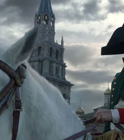 a man in a hat and coat standing next to a white horse