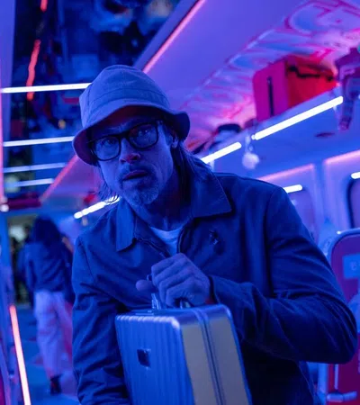 a man with a cigarette in his mouth and a suitcase in a bus