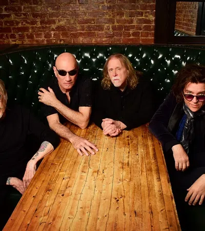 Warren Haynes et al. sitting at a table posing for the camera