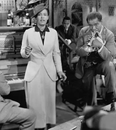 Louis Armstrong pouring a drink into a glass