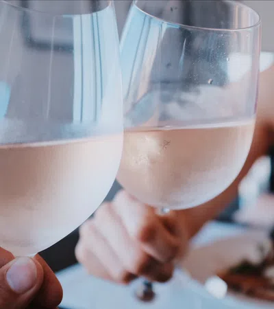 a couple of people hold wine glasses