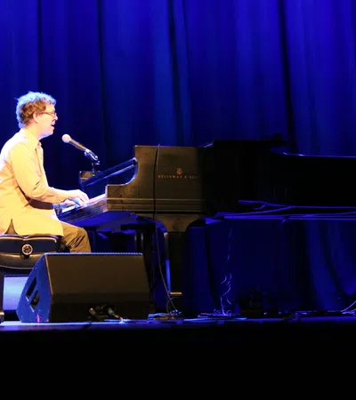 a man playing a piano on a stage