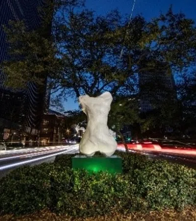 a statue of a person in a park with a city in the background