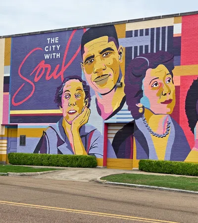 Colorful mural on a building wall depicting diverse faces with the text The City With Soul in vibrant colors.