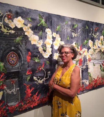 a person standing in front of a wall with flowers