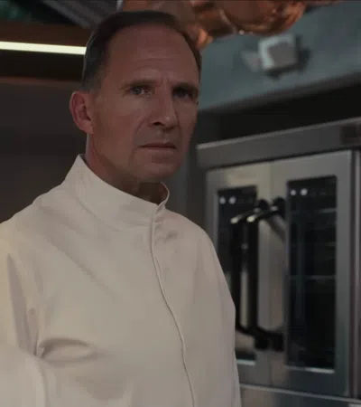Ralph Fiennes wearing a white coat