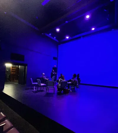 a group of people sitting in chairs in a room with blue lights
