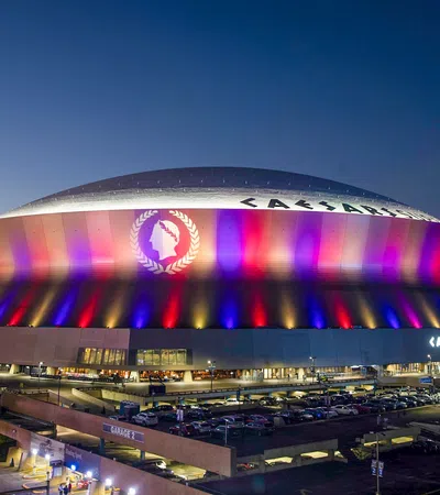 a stadium with a large roof with Mercedes-Benz Superdome in the background