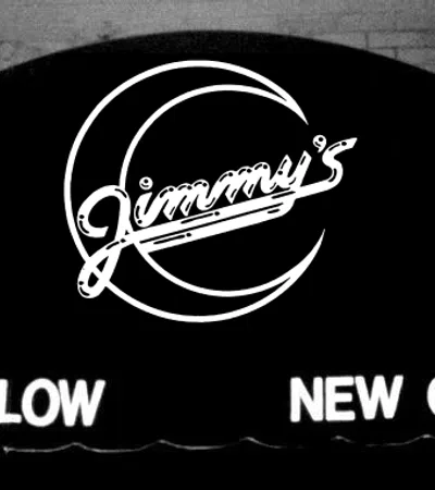 Black awning with white neon sign for Jimmy's at 8200 Willow in New Orleans on brick wall background